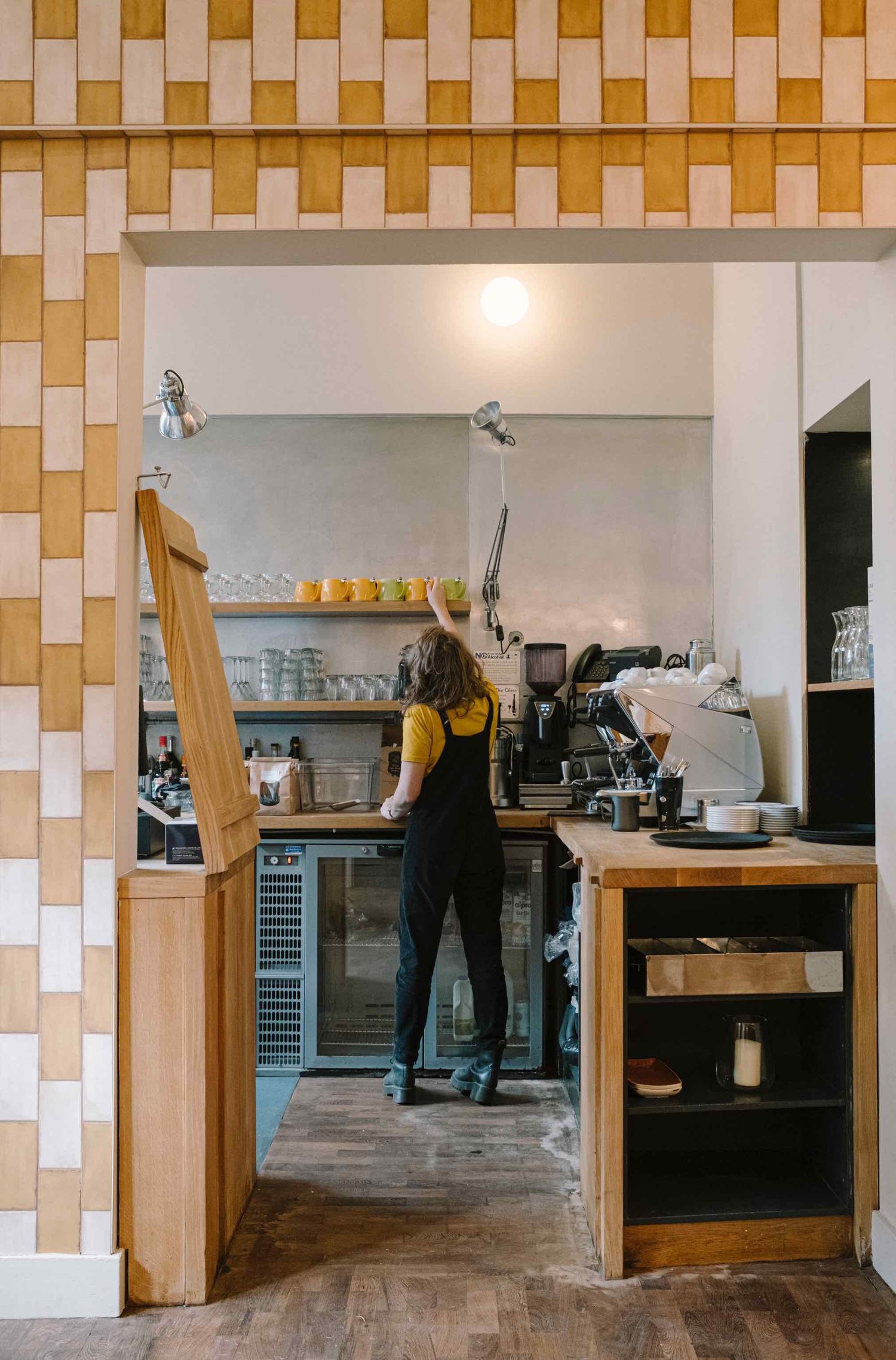 The tiled coffee-and-cocktail bar at Hendersons, with a member of the team at work