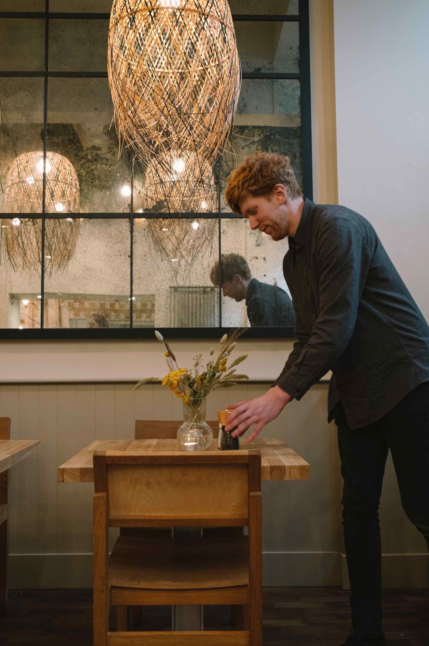 Barrie Henderson setting a table at Hendersons