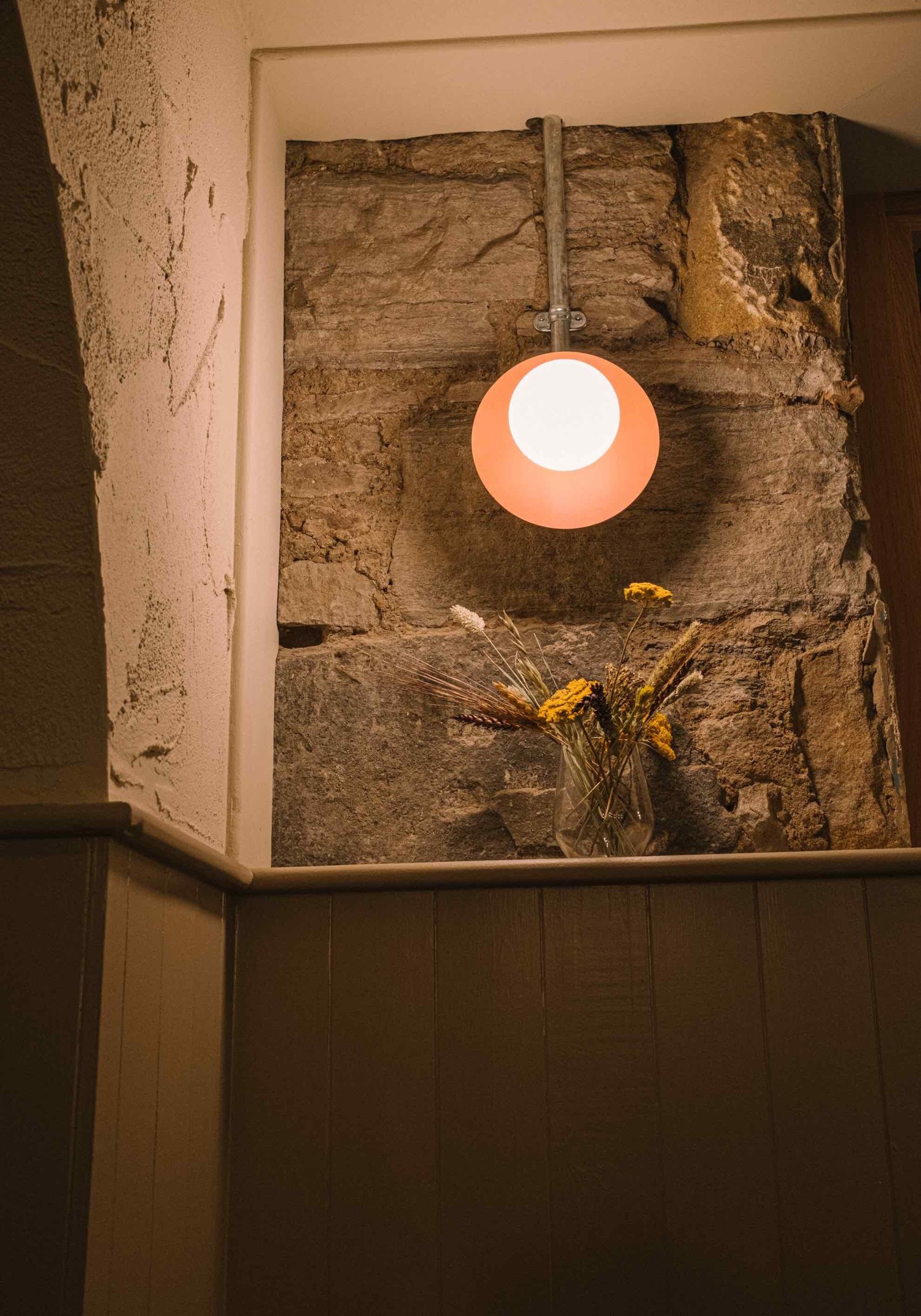 A brass light detail among dried foliage at Hendersons